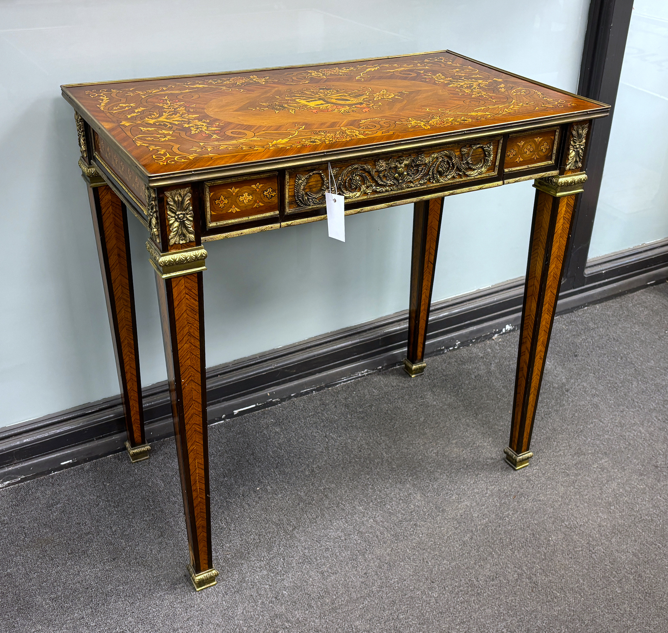 A Louis XVI style floral marquetry side table, the top inlaid with a musical trophy, width 80cm, depth 47cm, height 78cm